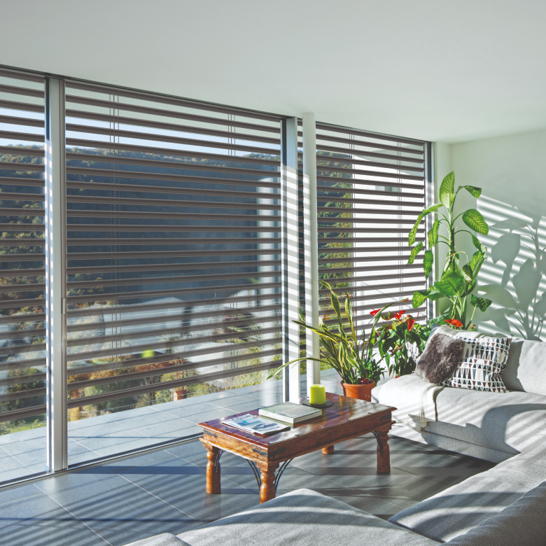 Vue intérieur d'un salon avec brise soleil orientables rénovation de couleur marron de la marque Flip, fabricant français de volets roulants