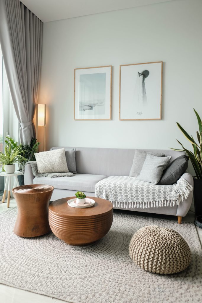 Intérieur salon avec canapé, table basse et pouf, ambiance cosy, couleur neutre