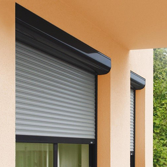 Façade orange d'une maison avec des volets roulants astrolux renolux gris noirs de la marque Flip