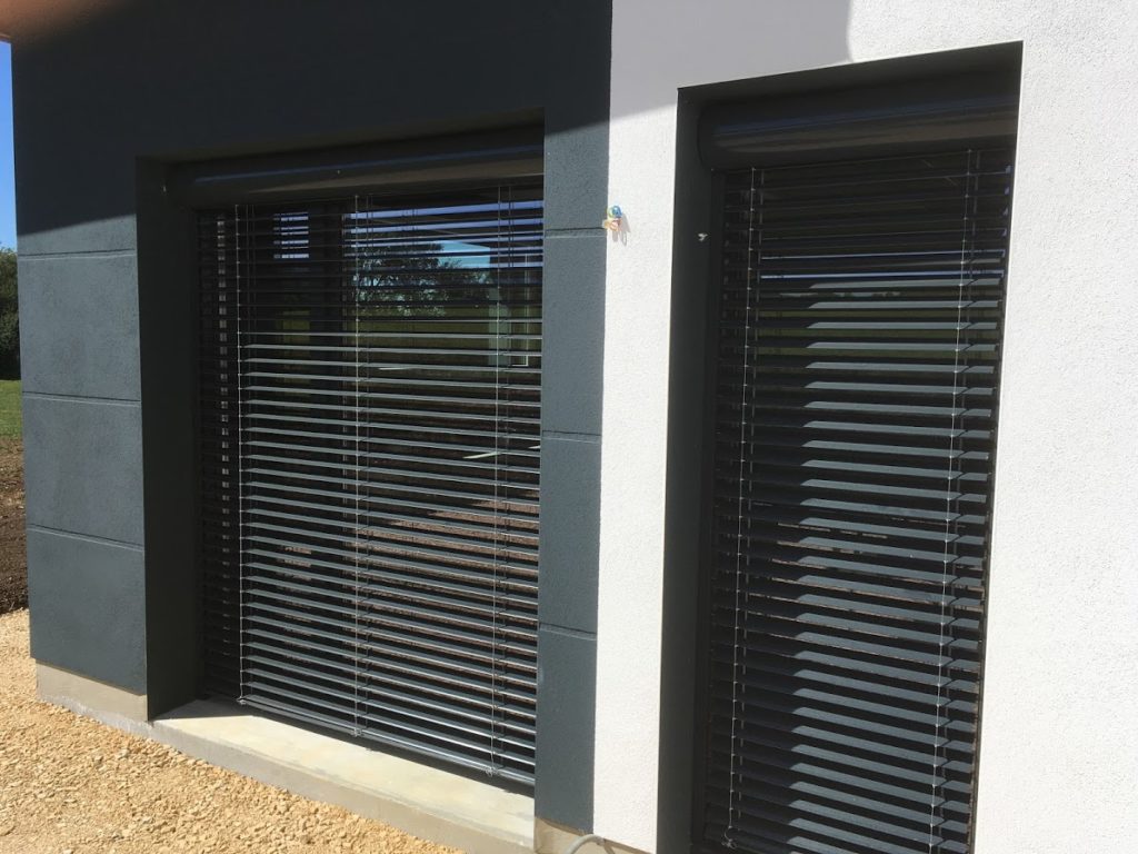 brise-soleil orientable noir sur baie-vitrée installée à valdahon