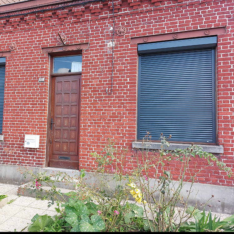 Fenetre avec volet roulant renolux astrolux noir, de la marque Flip, d'une maison en brique rouge