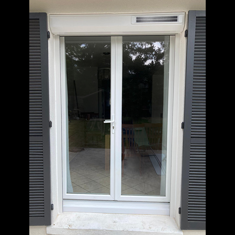 Porte fenetre avec des volets en bois gris et un volet roulant renosun astrosun blanc de la marque Flip