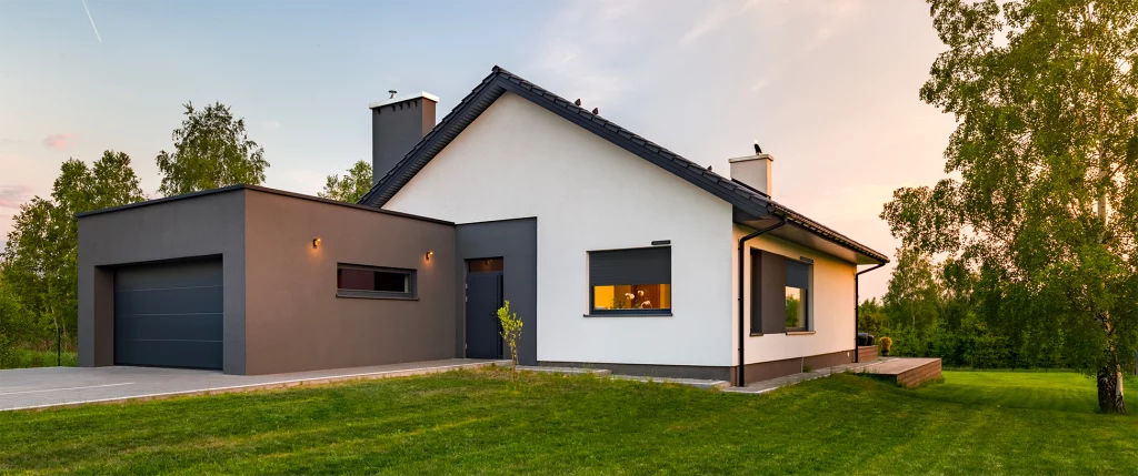 Maison moderne équipée d'une porte de garage sectionnelle et de volets roulants de la marque FLIP, fabricant français