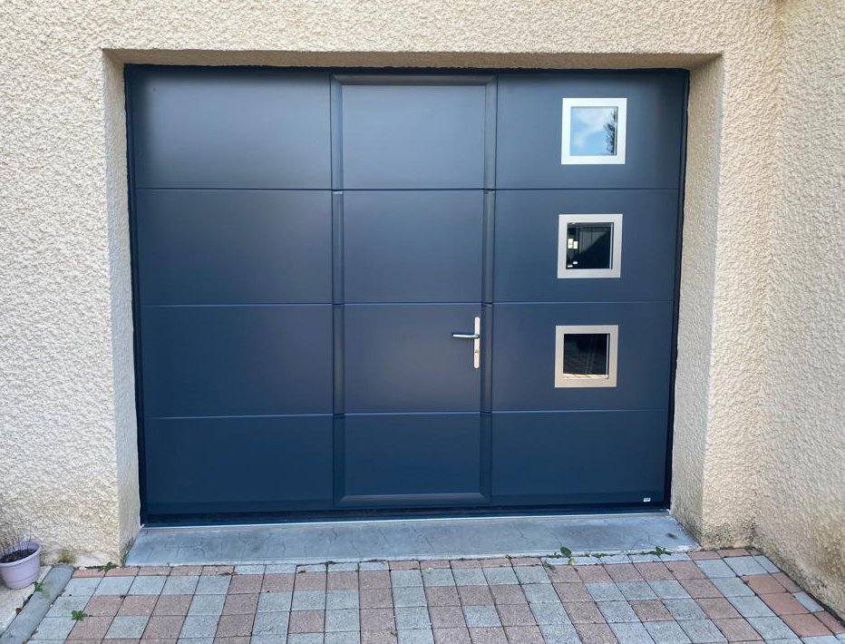 Porte de garage sectionnelle anthracite avec portillon et hublots à Chaspuzac en Haute Loire